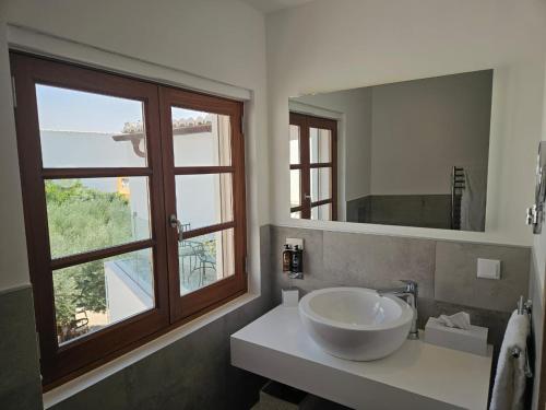 a bathroom with a sink and a large window at Eleven, Boutique luxury house & garden in Boliqueime