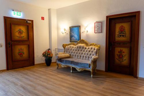 a waiting room with a couch and two doors at Schloss Höfingen in Leonberg