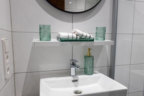 a white bathroom with a sink and a mirror at Schloss Höfingen in Leonberg