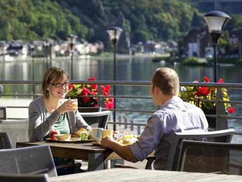 un uomo e una donna seduti a un tavolo che mangiano di ibis Dinant Centre a Dinant