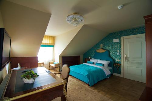a bedroom with a blue bed and a table at Willa Różana in Nałęczów