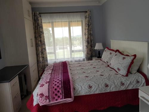 a bedroom with a large bed and a window at Ashley's Cottage in Himeville