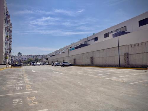 a parking lot with cars parked next to a building at Depa cómodo y práctico Excelente calidad-precio Zona tranquila in Guadalajara