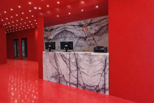 a lobby with a marble counter and red walls at BA Millenium in Buenos Aires