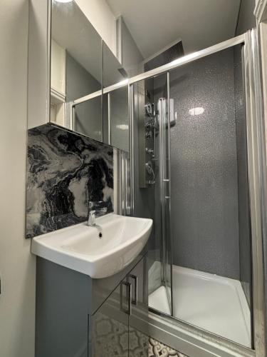 a bathroom with a sink and a shower at Louise Suite in Southport
