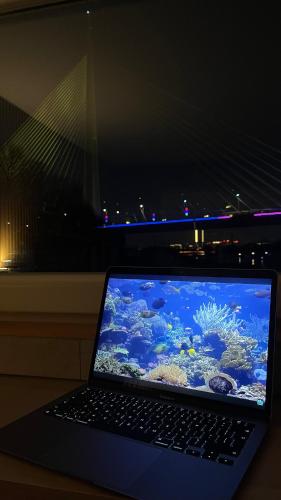 un ordinateur portable posé sur une table avec un aquarium dans l'établissement Oh, Mon Bateau! No running water, bez tekuce vode, à Belgrade