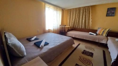 een hotelkamer met twee bedden en een raam bij Къща за гости Казакови in Kotel