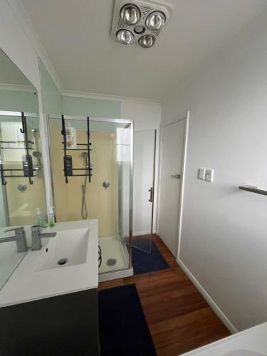 a bathroom with a white sink and a shower at Cosy Corner in Hamilton