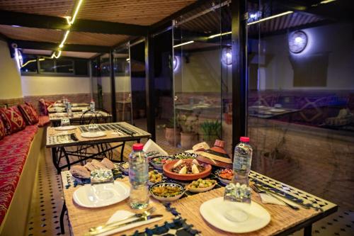 a table with plates of food and water bottles at Shauala Riad - Where History Lives in Fès