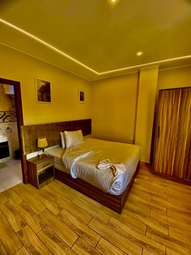 ein Schlafzimmer mit einem Bett und einem Holzboden in der Unterkunft Pyramidsfort & free pickup shuttle in Giza