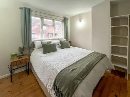 a bedroom with a large bed and a window at Tap Cottage in Burgh le Marsh