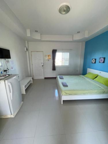 a large room with a bed and a refrigerator at The Rich Home in Nakhon Ratchasima