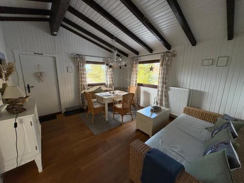- un salon avec un lit et une table à manger dans l'établissement Ferienhaus Bärenloch, à Hilders