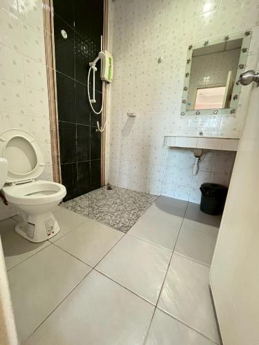 a bathroom with a toilet and a shower at The Rich Home in Nakhon Ratchasima