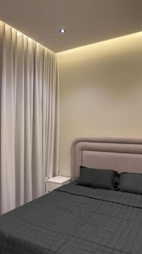 een slaapkamer met een bed en een wit gordijn bij Supreme suites in Al Kharj