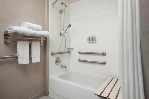 une salle de bain avec baignoire et douche avec serviettes dans l'établissement Residence Inn by Marriott Fort Collins, à Fort Collins