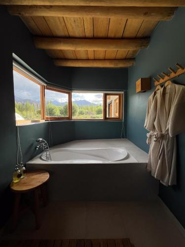 a bath tub in a bathroom with a window at The Indus River Camp in Leh