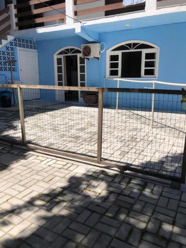 a fence in front of a blue house at Kitnet centro de bombinhas in Bombinhas