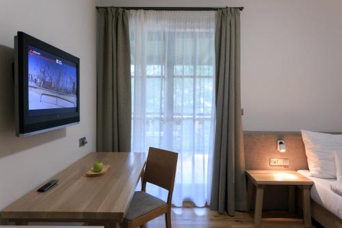 a living room with a dining table and a television at Hotel a restaurace U Vychopňů in Vsetín
