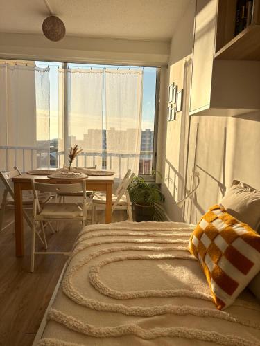 a bedroom with a bed and a table and a window at À 1min à pied de la mer, studio lumineux & cosy in Carnon-Plage