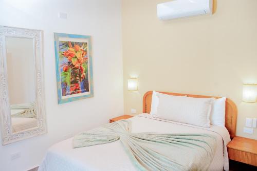 una camera da letto bianca con un letto e uno specchio di Central Hotel Boutique a Las Galeras