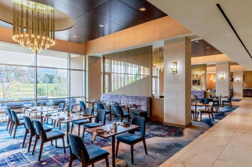 a restaurant with wooden tables and chairs and a large window at The Westin Washington Dulles Airport in Herndon