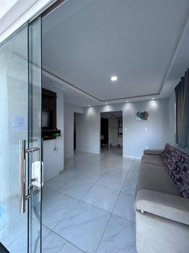 een woonkamer met een bank en een glazen wand bij Triplex Carapibus Beach in João Pessoa