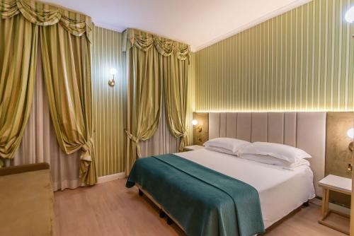 a bedroom with a large bed with yellow curtains at Gambrinus Hotel in Rome