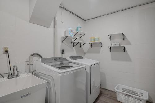 a white laundry room with a washer and a sink at The Art Deco Den in Tampa