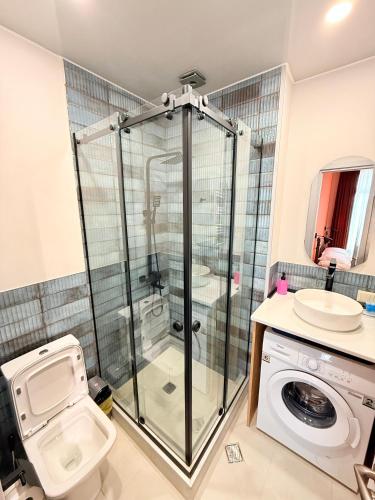a bathroom with a shower and a toilet and a sink at Cosy City-View Flat in Mtatsminda, flat 7 in Itʼkhvisi