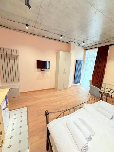 a bedroom with a bed and a tv on the wall at Cosy City-View Flat in Mtatsminda, flat 7 in Itʼkhvisi