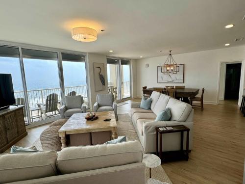 een woonkamer met een bank en een tafel met uitzicht bij Beachfront Penthouse w Gulf & Bay Views in Gulf Highlands