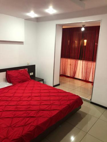 a large red bed in a room with a window at Central suite in Piteşti