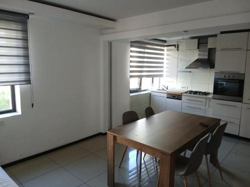 una cucina con tavolo e sedie in legno di Central suite a Piteşti