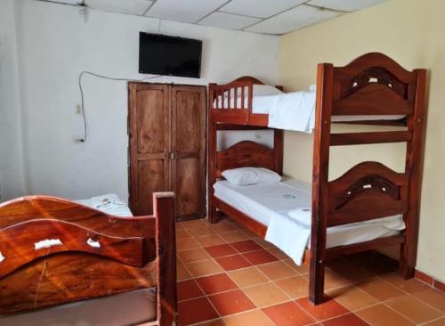 a bedroom with two bunk beds and a flat screen tv at Casa Faccioli in Mompos