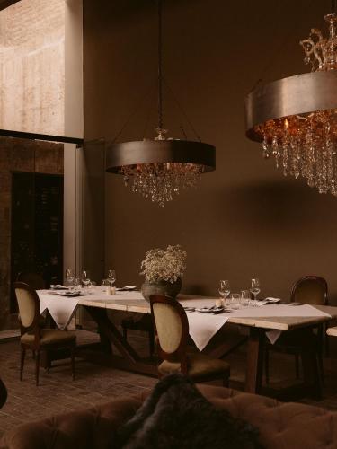 阿雷基帕CIRQA - Relais & Châteaux的用餐室配有白色桌椅和吊灯。