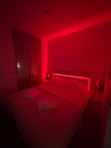 a red room with a bed with a red light at Nali Room in La Vespière