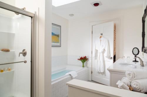 een witte badkamer met een wastafel en een bad bij Chesterfield Inn in West Chesterfield