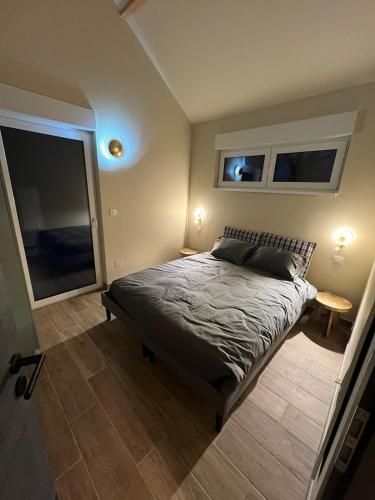 a bedroom with a bed and two windows at Le chalet O'Perché - Wissembourg in Wissembourg