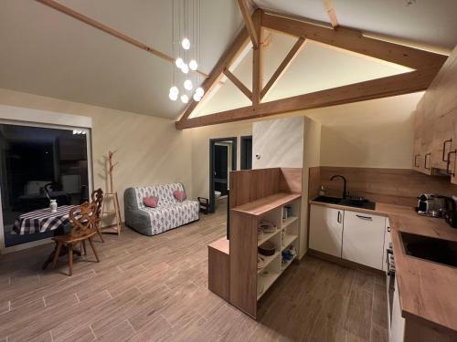 eine Küche und ein Wohnzimmer mit einem Tisch und einer Couch in der Unterkunft Le chalet O'Perché - Wissembourg in Wissembourg