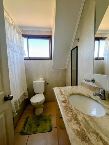 a bathroom with a sink and a toilet at Casa en Pingueral para 7 personas in Dichato
