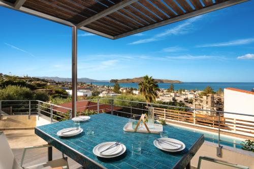 a table on a balcony with a view of the ocean at Seaview Garden Villa - Heated Pool & Sauna in Stalos