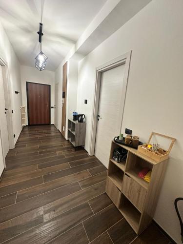 a hallway with white walls and a wooden floor at Dante appartamento in Fagnano Olona