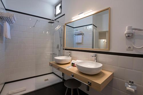 a bathroom with two sinks and a mirror at B&B HOTEL Apartamentos Madrid Centro Fuencarral 46 in Madrid