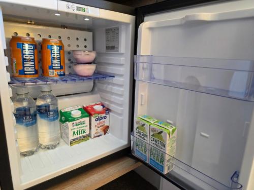 an open refrigerator with milk and drinks in it at Mizpah Bed & Breakfast near Ben Nevis Highlands in Roybridge