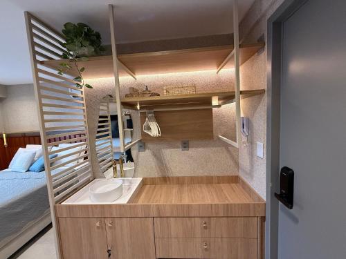 ein kleines Badezimmer mit Waschbecken und Bett in der Unterkunft Garden Haus Beira-Mar, Jardim Oceania-Miramar Hospedagens in Tambaú