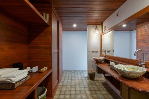 a bathroom with a large bowl sink and wooden walls at PingChan Koh Phangan Beachfront Resort in Thong Nai Pan Yai