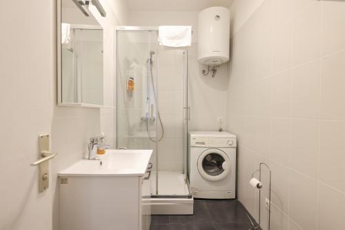a bathroom with a washing machine and a washer at Quattro Cantoni Apartment in Zadar
