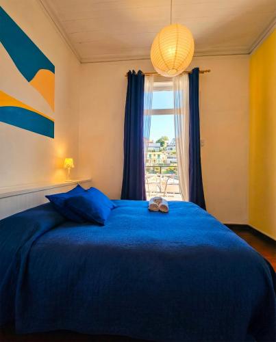 a bedroom with a blue bed and a window at La Galería B&B in Valparaíso
