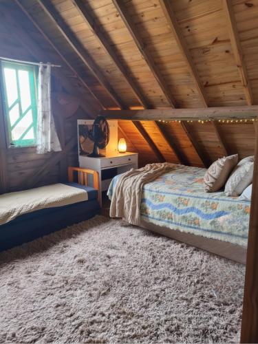 een slaapkamer met een bed in een houten plafond bij Casa Rústica em Garopaba in Garopaba